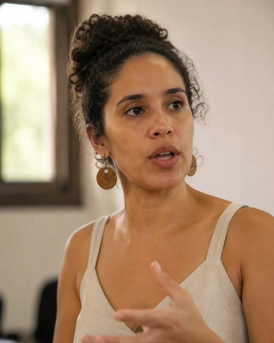 Participante em pé no meio da roda, segurando a folha de anotações enquanto fala